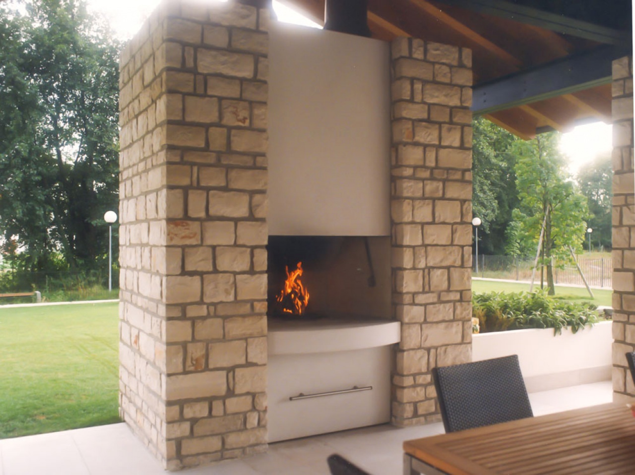Caminetto barbecue sottoportico, inserito su colonne in pietra a spacco